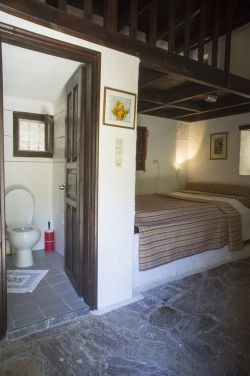 bathroom with toilet and shower and double bed.